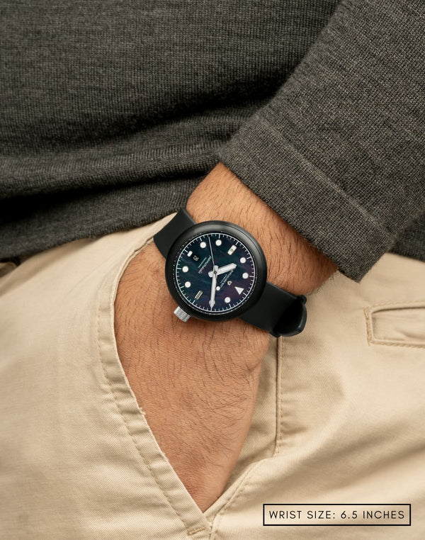 Man wearing Mannar wristwatch with hand in pocket, featuring the striking mother of pearl dial and sleek stainless steel case.